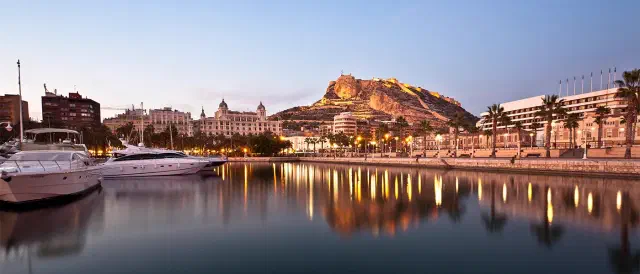 Foto tijdens schemering in de haven van Alicante met het kasteel op de achtergrond.