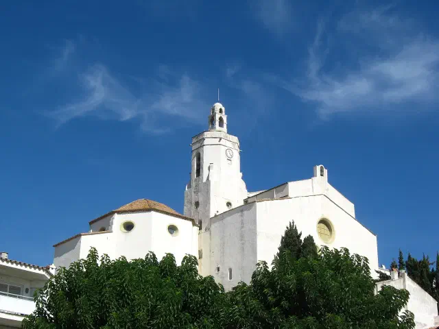 De zeventiende-eeuwse Església de Santa Maria op de heuvel boven Cadaqués met witte gevel en zandstenen klokkentoren