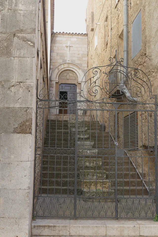 Zij-ingang van de Església de Sant Pere in Figueres via een smeedijzeren poort