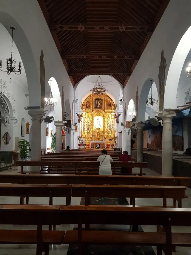 Het interieur van de Iglesia de la Inmaculada Concepción in Mijas met gouden altaar en houten plafond