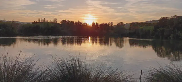 Ondergaande zon bij groot meer in Parc dels Estanys nabij Platja d'Aro Ondergaande zon bij groot meer in Parc dels Estanys nabij Platja d'Aro