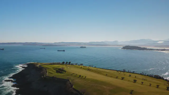 De groene Península de la Magdalena met uitzicht op de baai van Santander De groene Península de la Magdalena met uitzicht op de baai van Santander