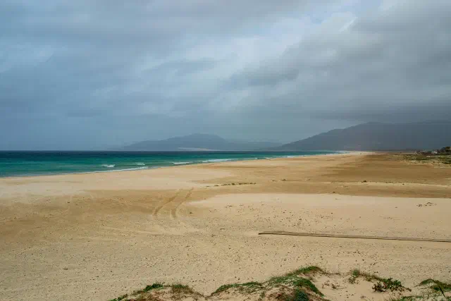 Het uitgestrekte Playa de los Lances strand van Tarifa met kitesurfers in het water